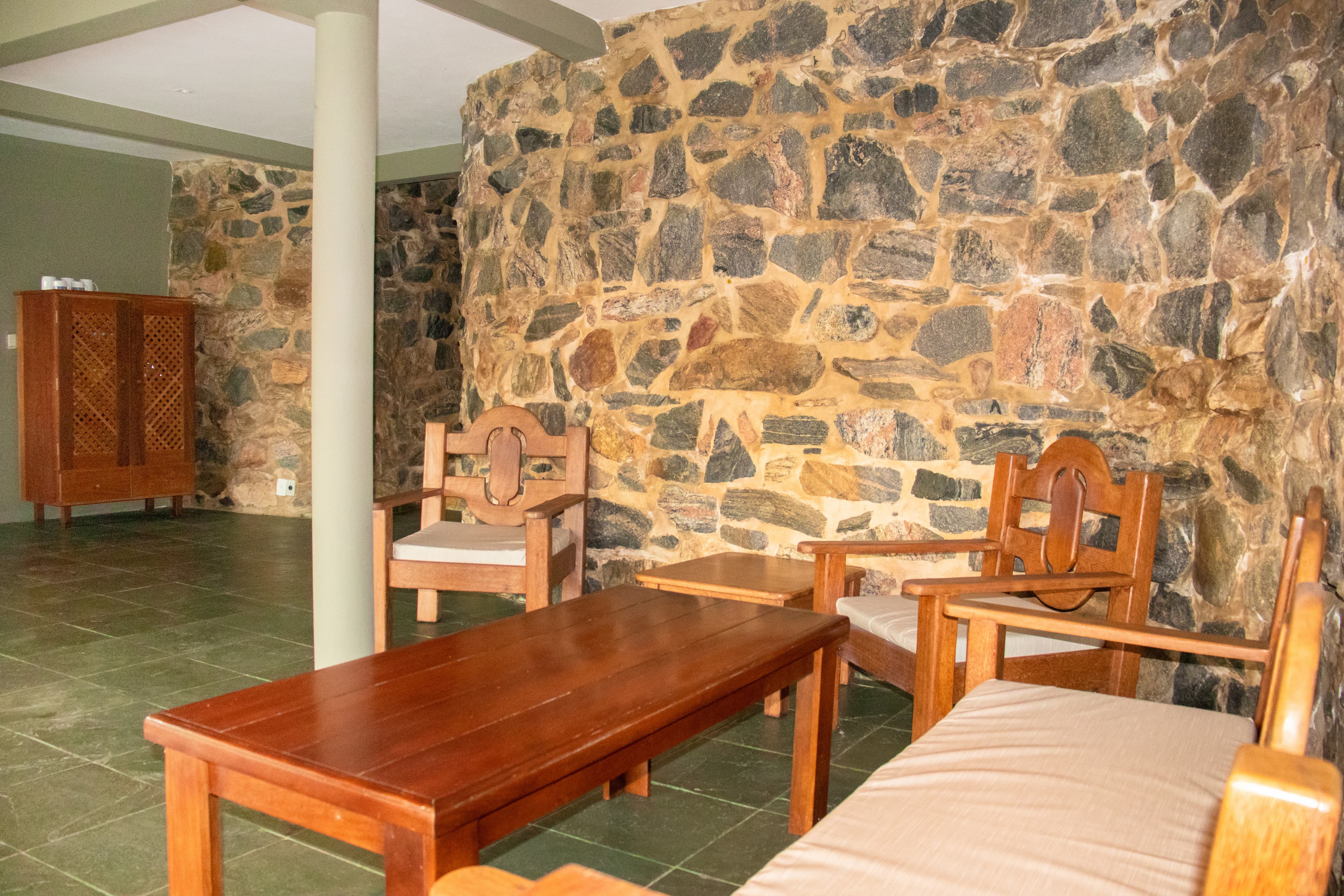 Sala de convivência com parede de pedra